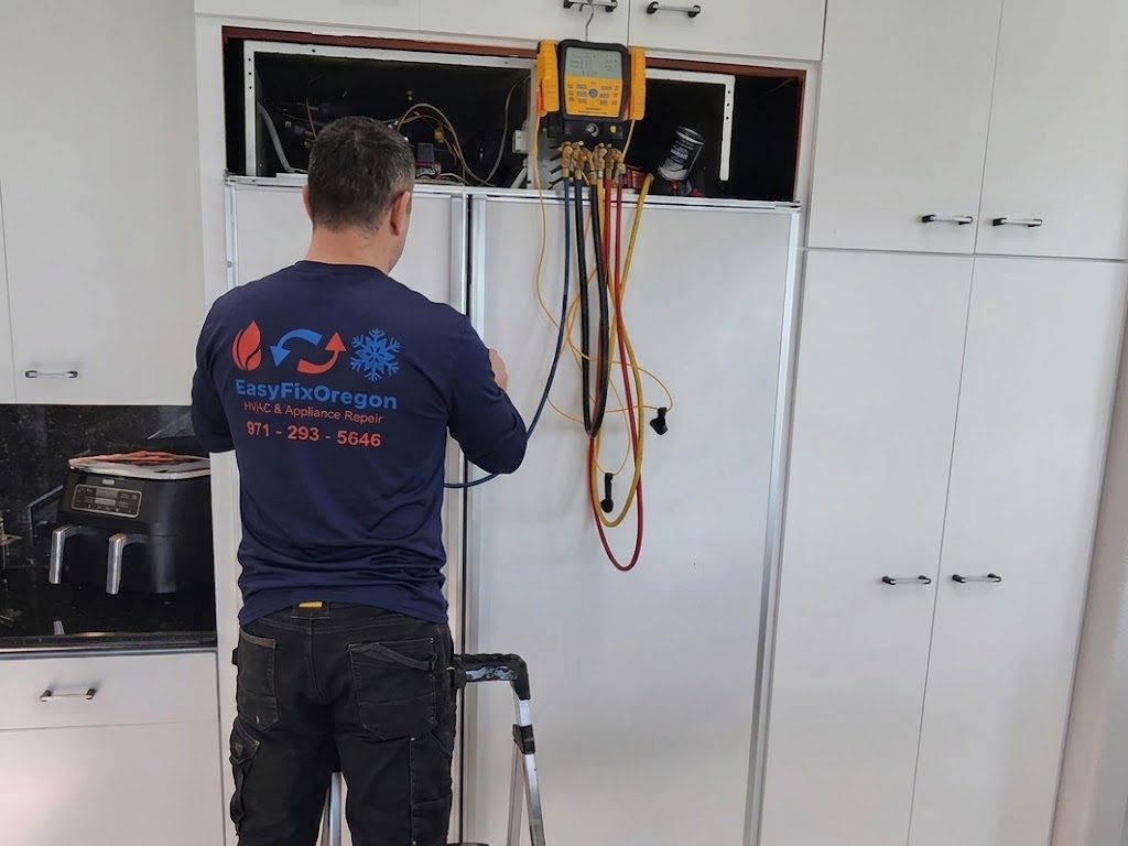 EasyFixOregon technician servicing a built-in refrigerator with digital gauges